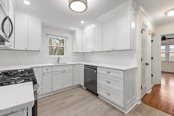 a kitchen with white cabinets and a stove