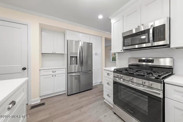 a kitchen with stainless steel appliances granite countertop a stove a refrigerator and a microwave