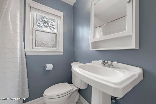 a bathroom with a sink mirror and toilet
