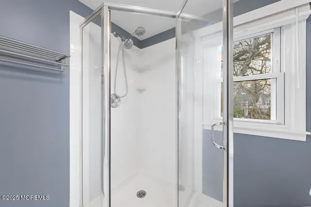a bathroom with a glass shower door and a glass door shower