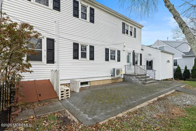 a view of a white house with a small yard and large tree