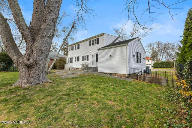a white house that has a tree in front of it