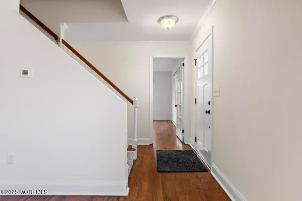 a view of a hallway with wooden floor and staircase