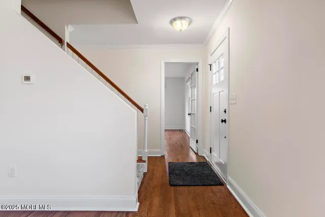 a view of a hallway with wooden floor and staircase