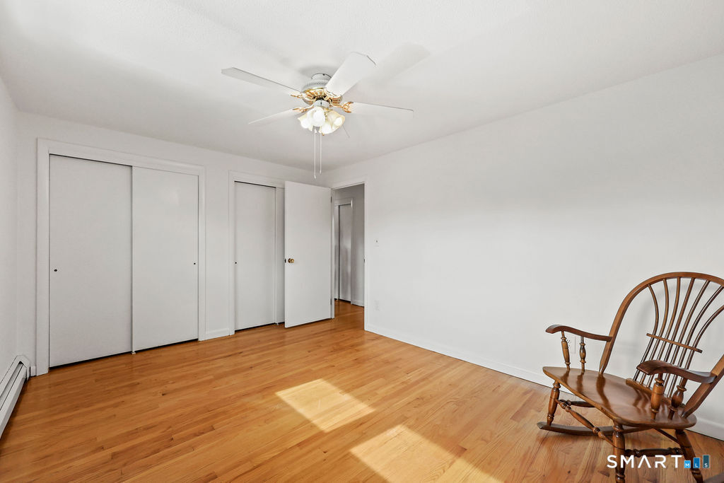 142 Wolcott Hill Road Wethersfield, CT 06109 - Photo 18 of 29 a bedroom with a bed and a chair
