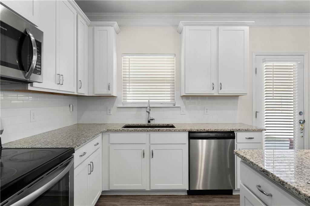 49 Thacker Trail Adairsville, GA 30103 - Photo 11 of 40 a kitchen with granite countertop white cabinets and a stove