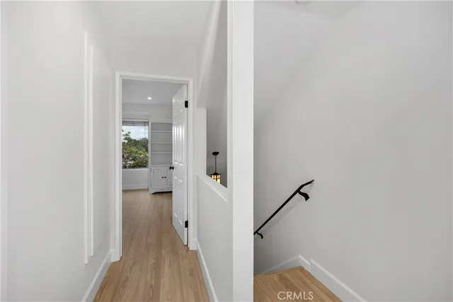 a view of a hallway with wooden floor and staircase