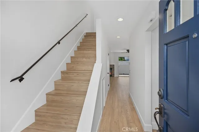 a view of a hallway with wooden floor and staircase