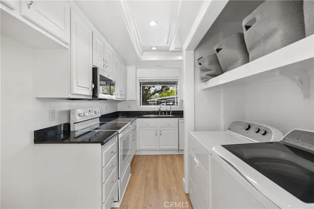 a kitchen with granite countertop a sink a stove and cabinets
