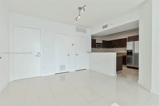 a view of kitchen with refrigerator and microwave