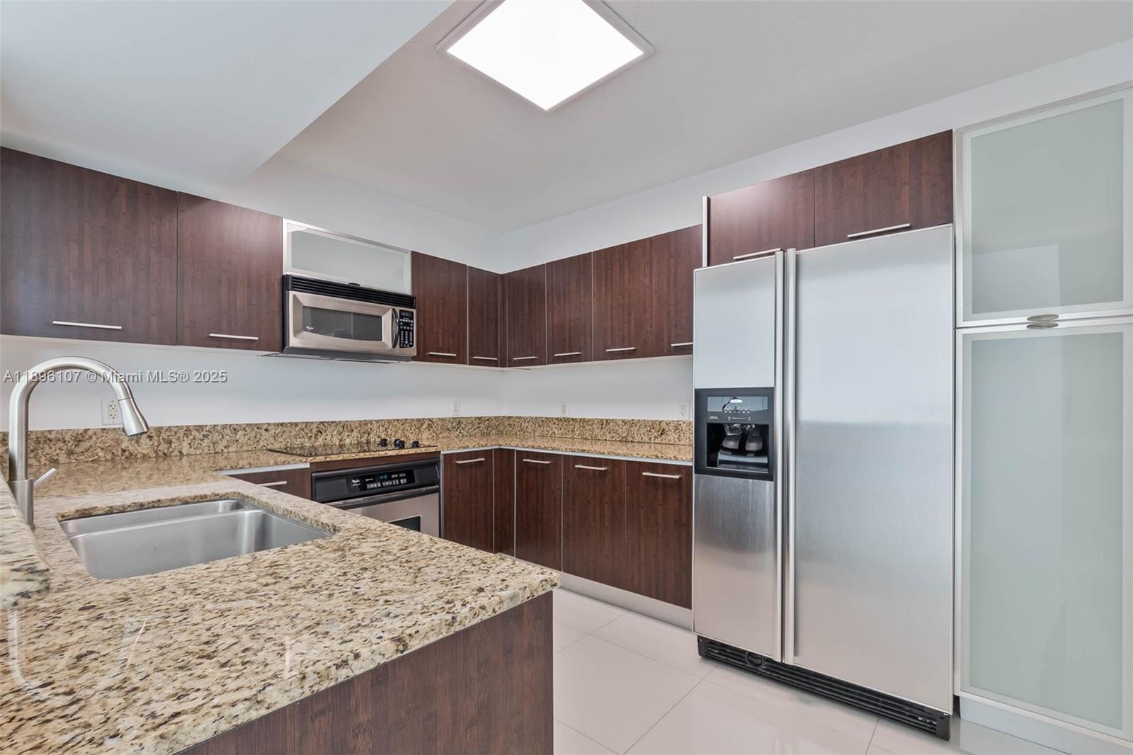 9055 Southwest 73rd Court, Unit 1402 Miami, FL 33156 - Photo 7 of 31 a kitchen with a refrigerator sink and cabinets