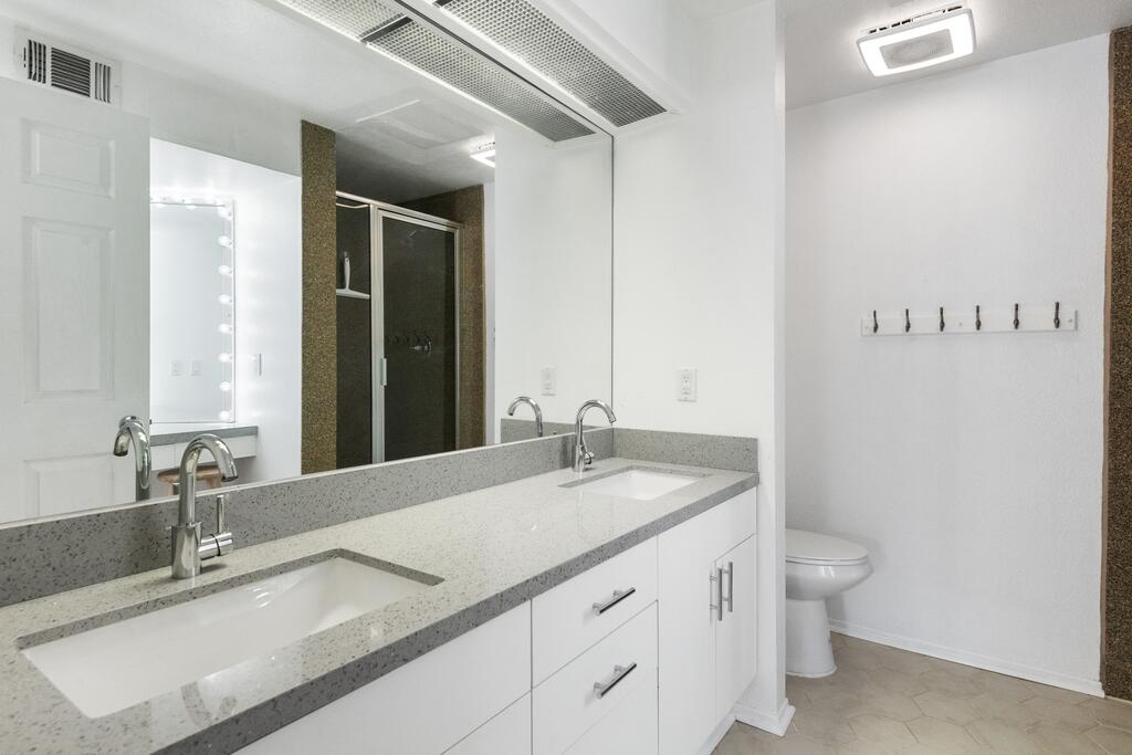68515 Risueno Road Cathedral City, CA 92234 - Photo 22 of 29 a bathroom with a granite countertop sink a toilet and a mirror