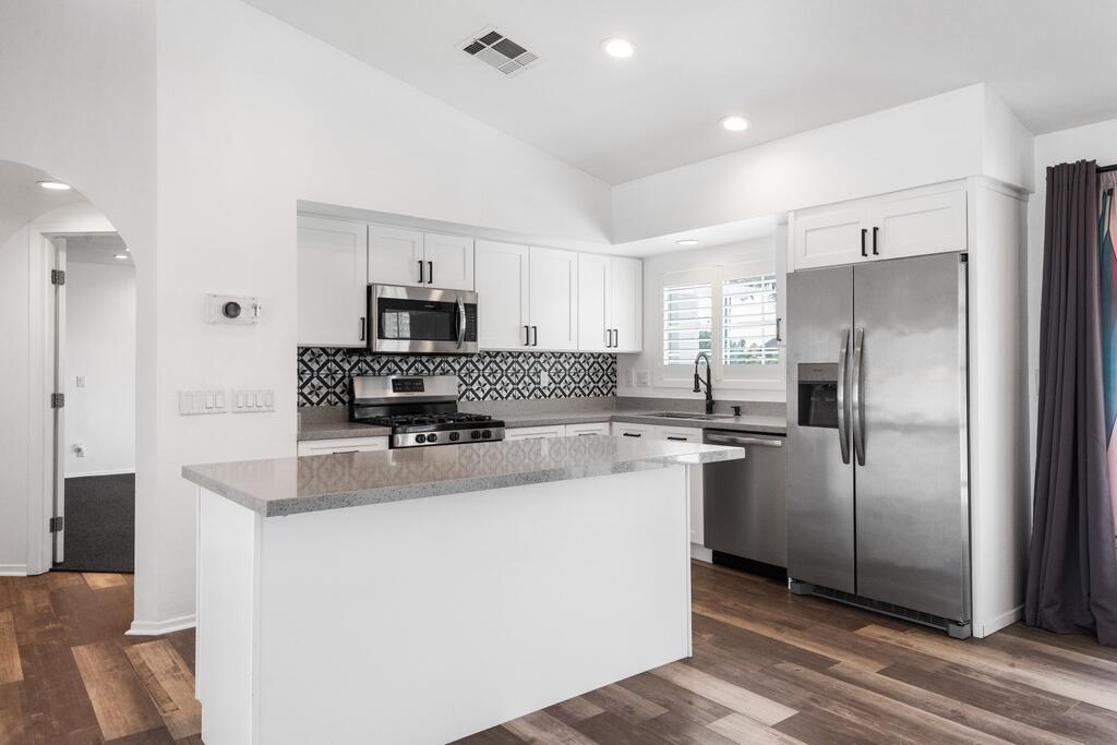 68515 Risueno Road Cathedral City, CA 92234 - Photo 8 of 29 a kitchen with kitchen island a refrigerator sink and microwave
