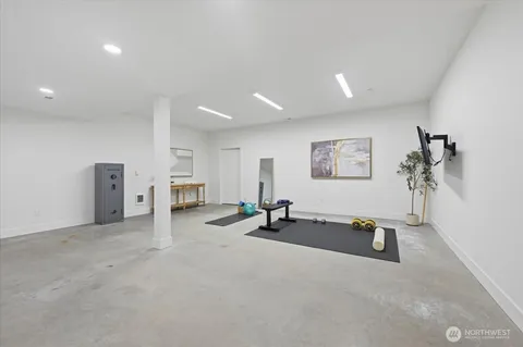 an empty room with gym equipment and view of living room