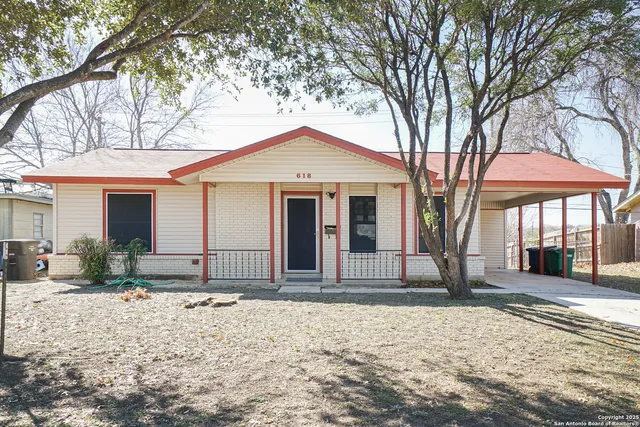 a front view of a house with a yard and potted plants