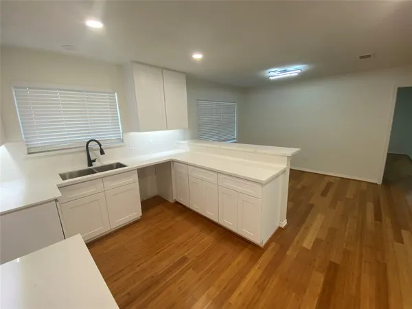 a view of a sink and dishwasher with wooden floor