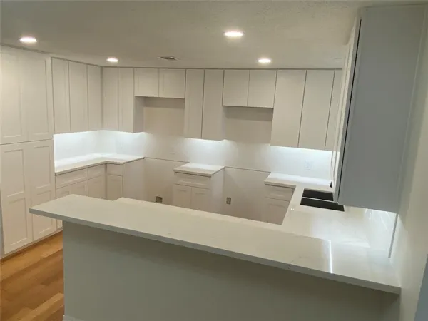 a view of a kitchen with white cabinets