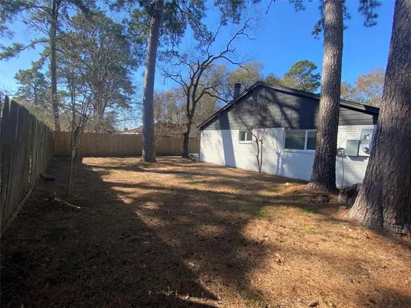 a view of a yard with wooden fence