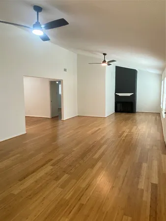 a view of an empty room with a chandelier fan
