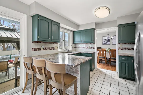 a kitchen with stainless steel appliances granite countertop a sink and a refrigerator
