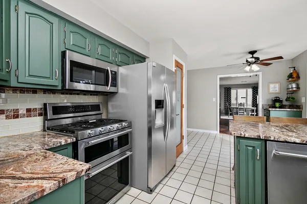 a kitchen with granite countertop a stove cabinets and stainless steel appliances