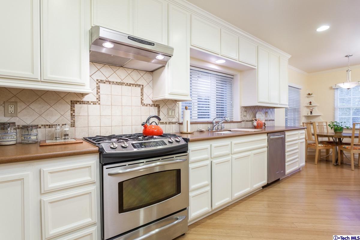 44 San Miguel Road Pasadena, CA 91105 - Photo 8 of 18 a kitchen with stainless steel appliances a stove a sink and white cabinets