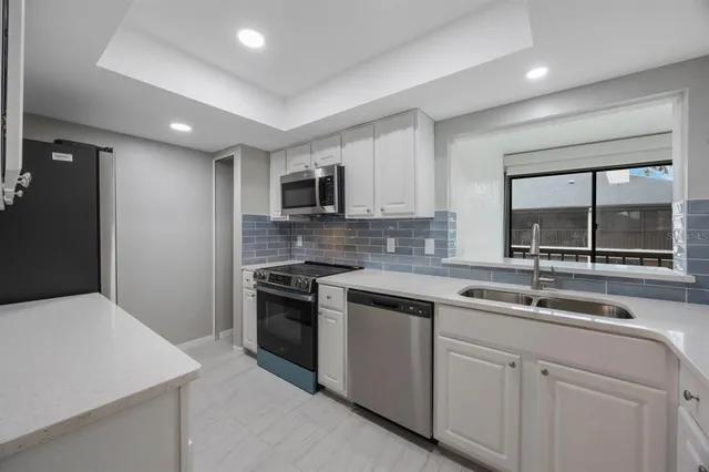 a kitchen with stainless steel appliances a stove microwave and sink