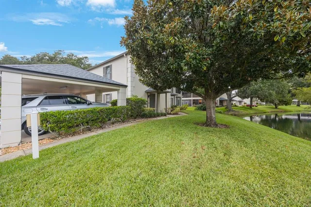 a view of a house with backyard and a tree