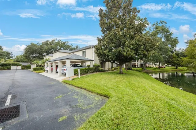 a view of a white house with a yard and sitting area