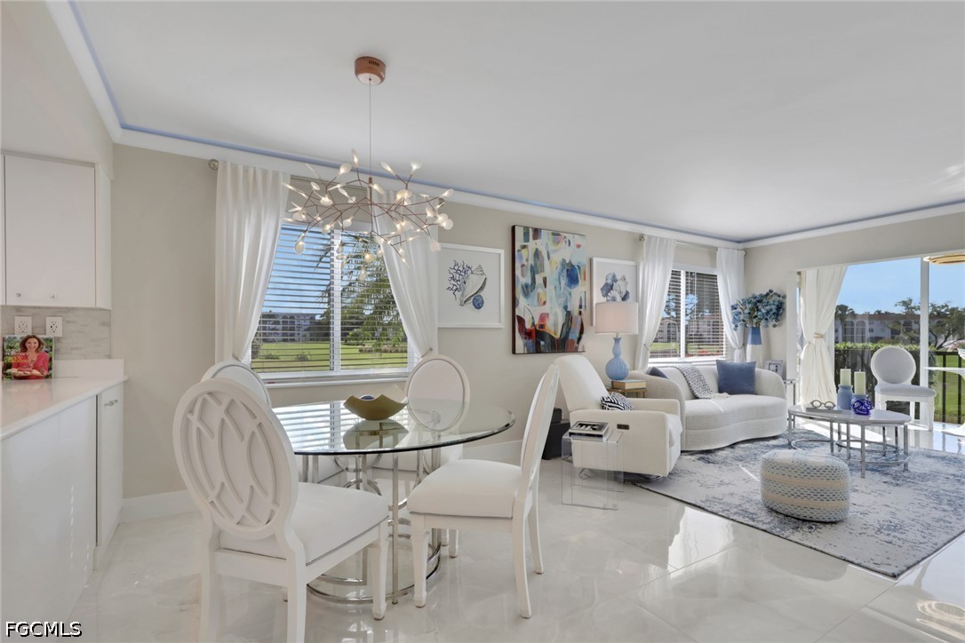 9 High Point Circle North, Unit 101 Naples, FL 34103 - Photo 4 of 49 a living room with furniture and a chandelier