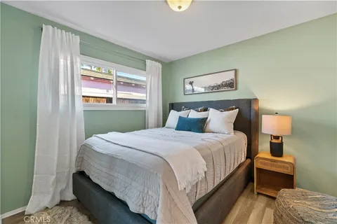 a bedroom with bed and wooden floor