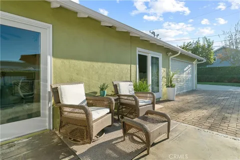 a view of a patio with table and chairs near a yard