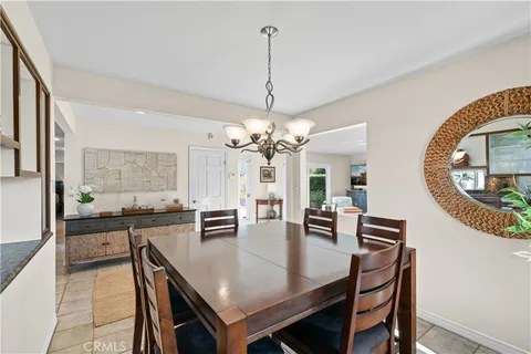 a view of a dining room and livingroom with furniture wooden floor and a chandelier