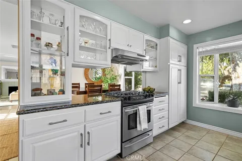 a kitchen with stainless steel appliances granite countertop a stove a sink and a refrigerator