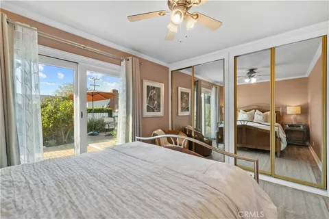 a bedroom with a bed and a large window with chair