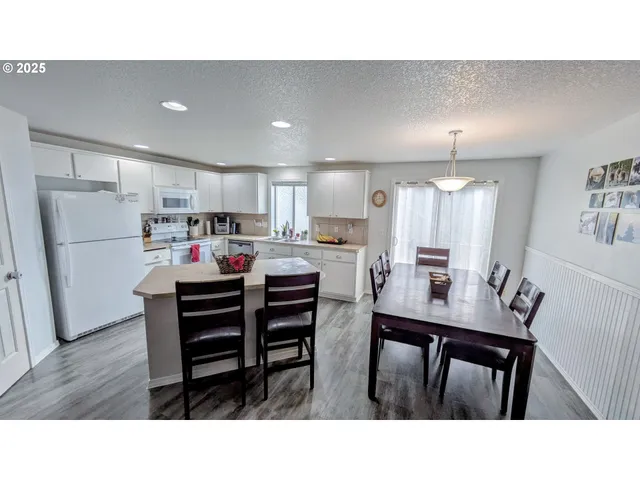 a kitchen with a table chairs refrigerator microwave and cabinets