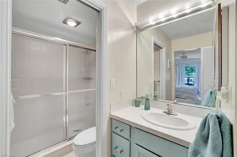 a bathroom with a sink toilet a mirror and shower