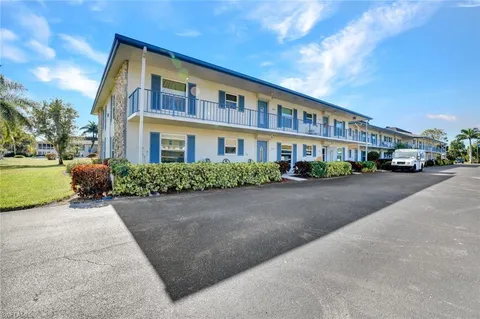 a city street lined with buildings and cars parked on the roadside