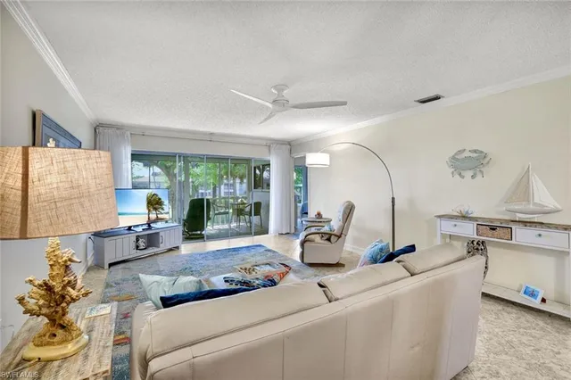 a living room with furniture a large window and potted plants