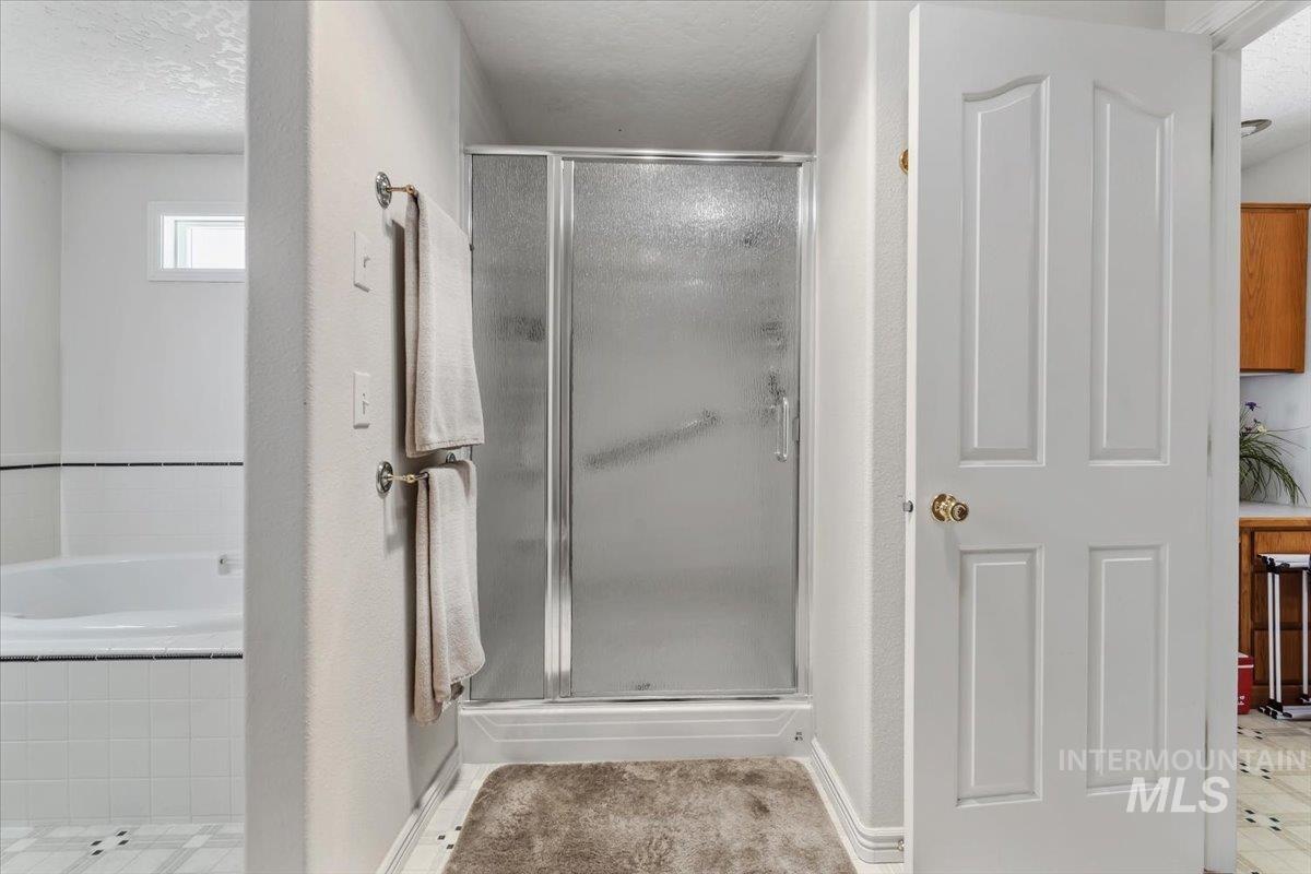 2331 Gulley Road Homedale, ID 83628 - Photo 21 of 46 Shower with frosted glass enclosure, white tile surround, and built-in grab bar