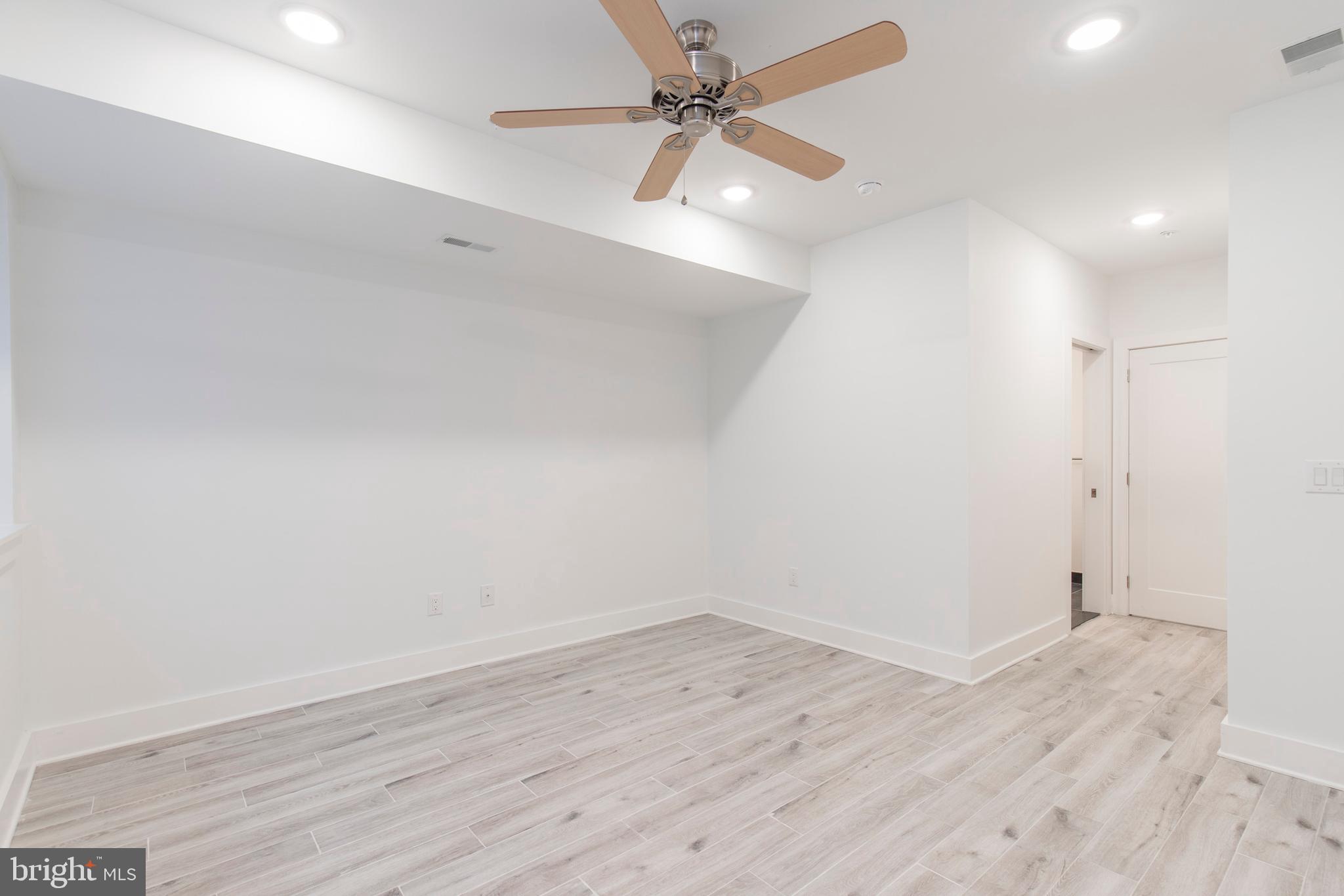 2412 Master Street, Unit A Philadelphia, PA 19121 - Photo 19 of 25 an empty room with wooden floor and fan