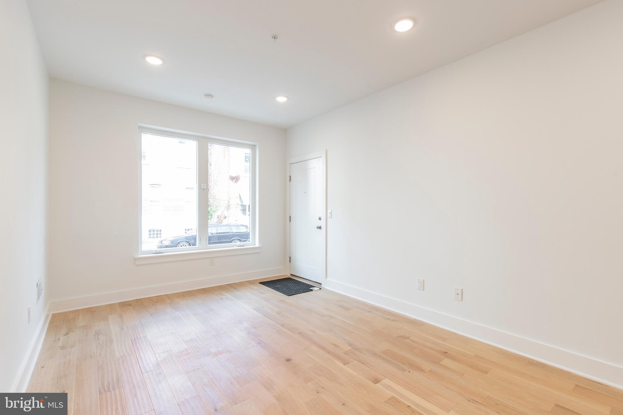 2412 Master Street, Unit A Philadelphia, PA 19121 - Photo 4 of 25 an empty room with wooden floor and windows