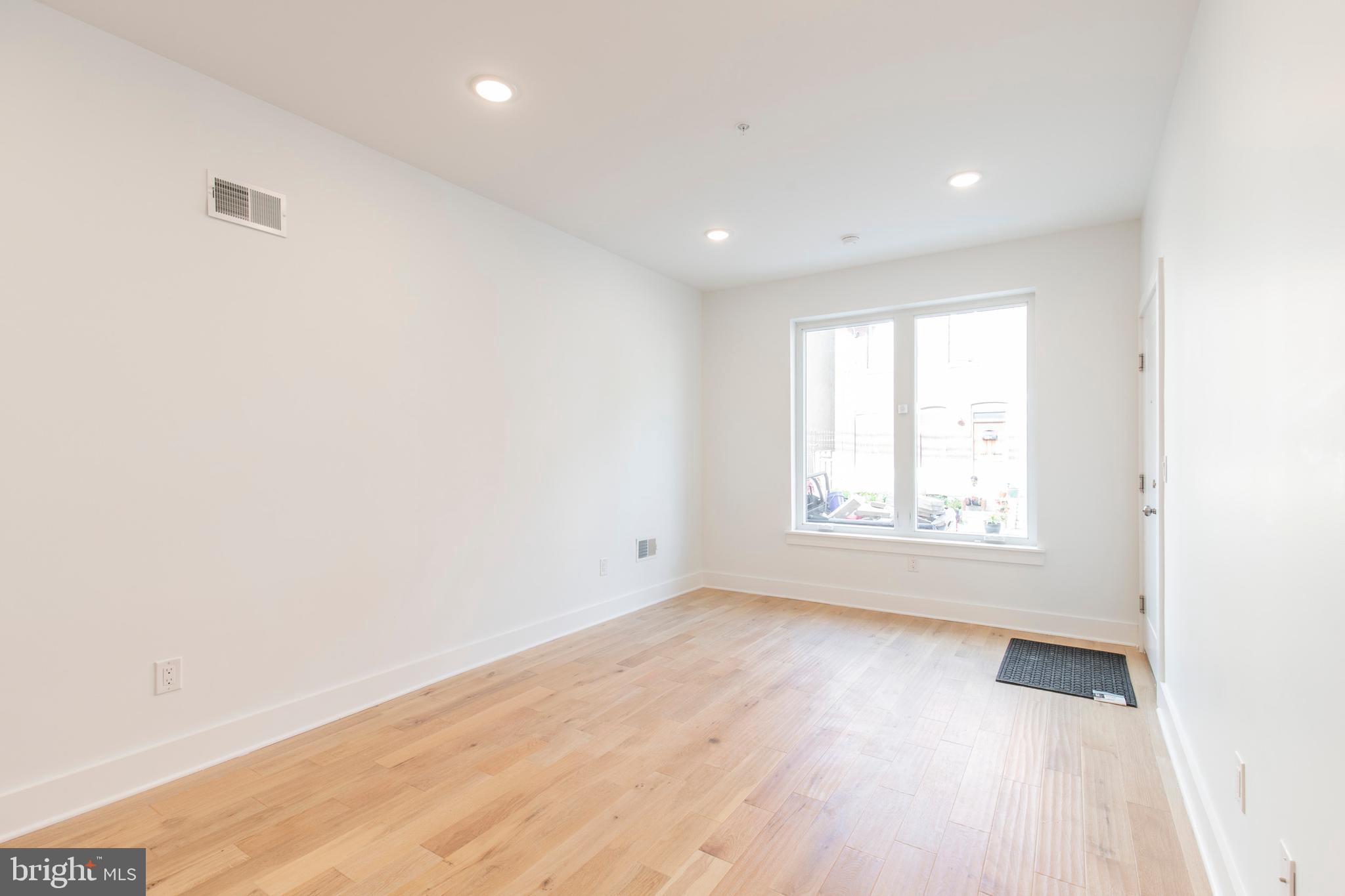 2412 Master Street, Unit A Philadelphia, PA 19121 - Photo 5 of 25 an empty room with wooden floor and windows