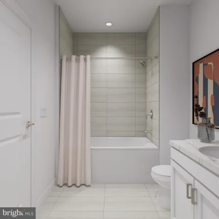 a bathroom with a granite countertop bathtub shower sink vanity and toilet