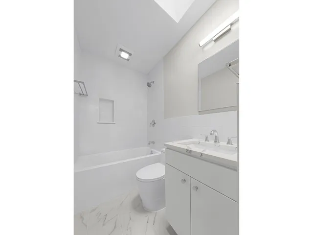 a view of an empty room with a fireplace and window