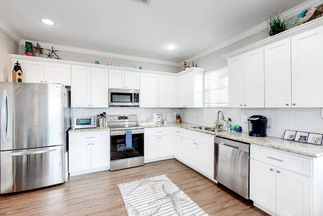 a kitchen with white cabinets and white appliances