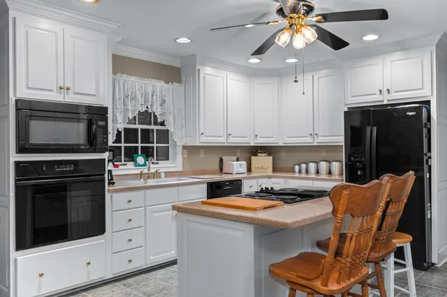 a kitchen with stainless steel appliances kitchen island granite countertop a stove a sink and a refrigerator