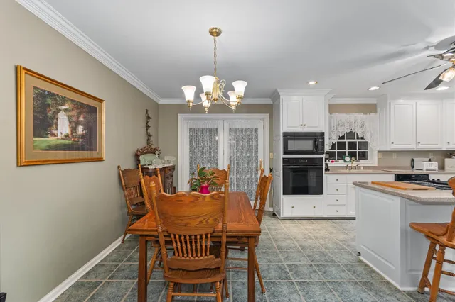 a dining room with furniture a chandelier and window