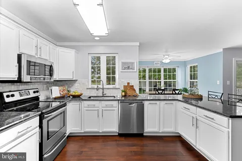 a kitchen with stainless steel appliances granite countertop a sink and cabinets