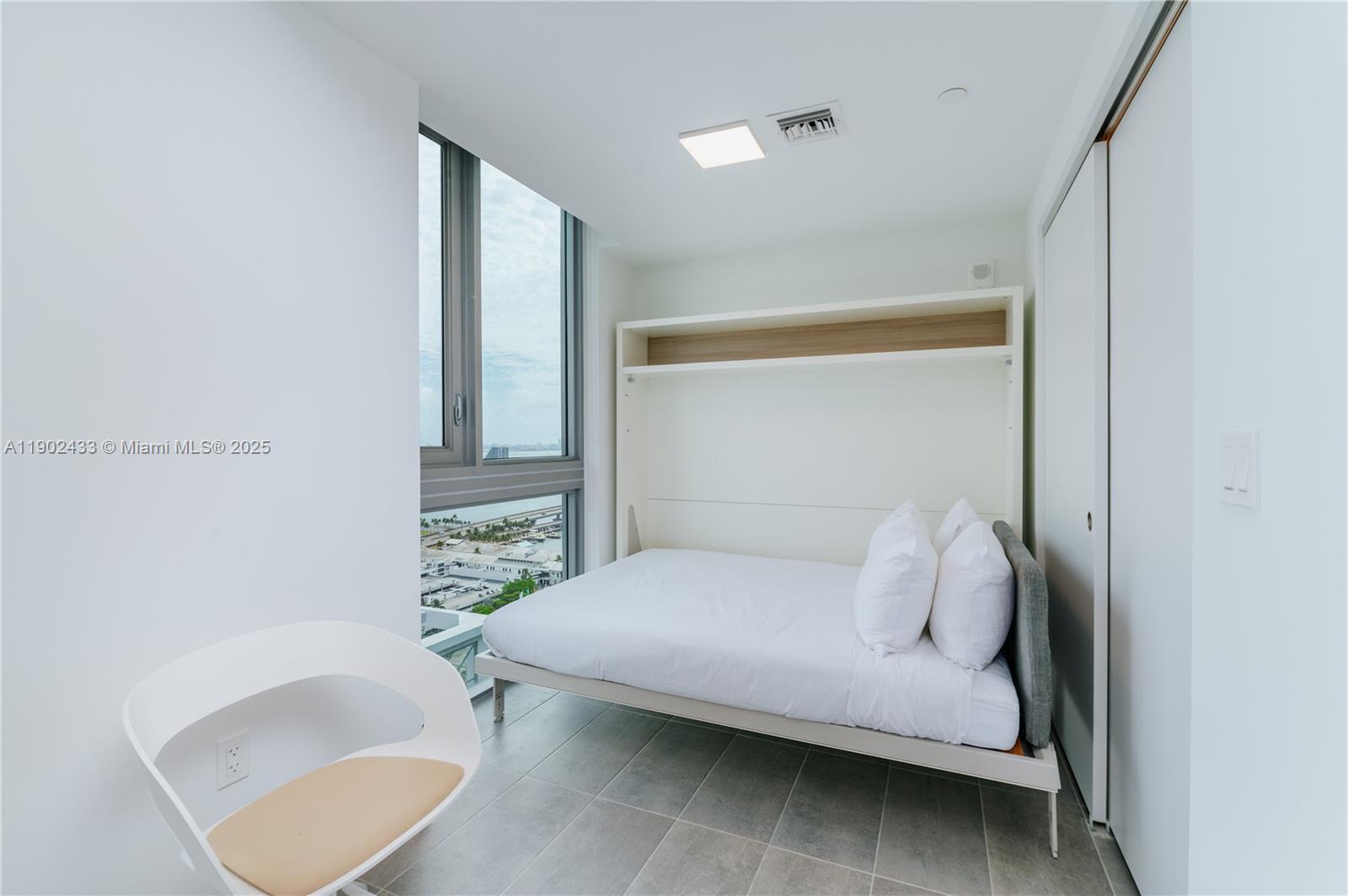 227 Northeast 2nd Street, Unit 2908 Miami, FL 33132 - Photo 6 of 21 a bedroom with a bed and a chair